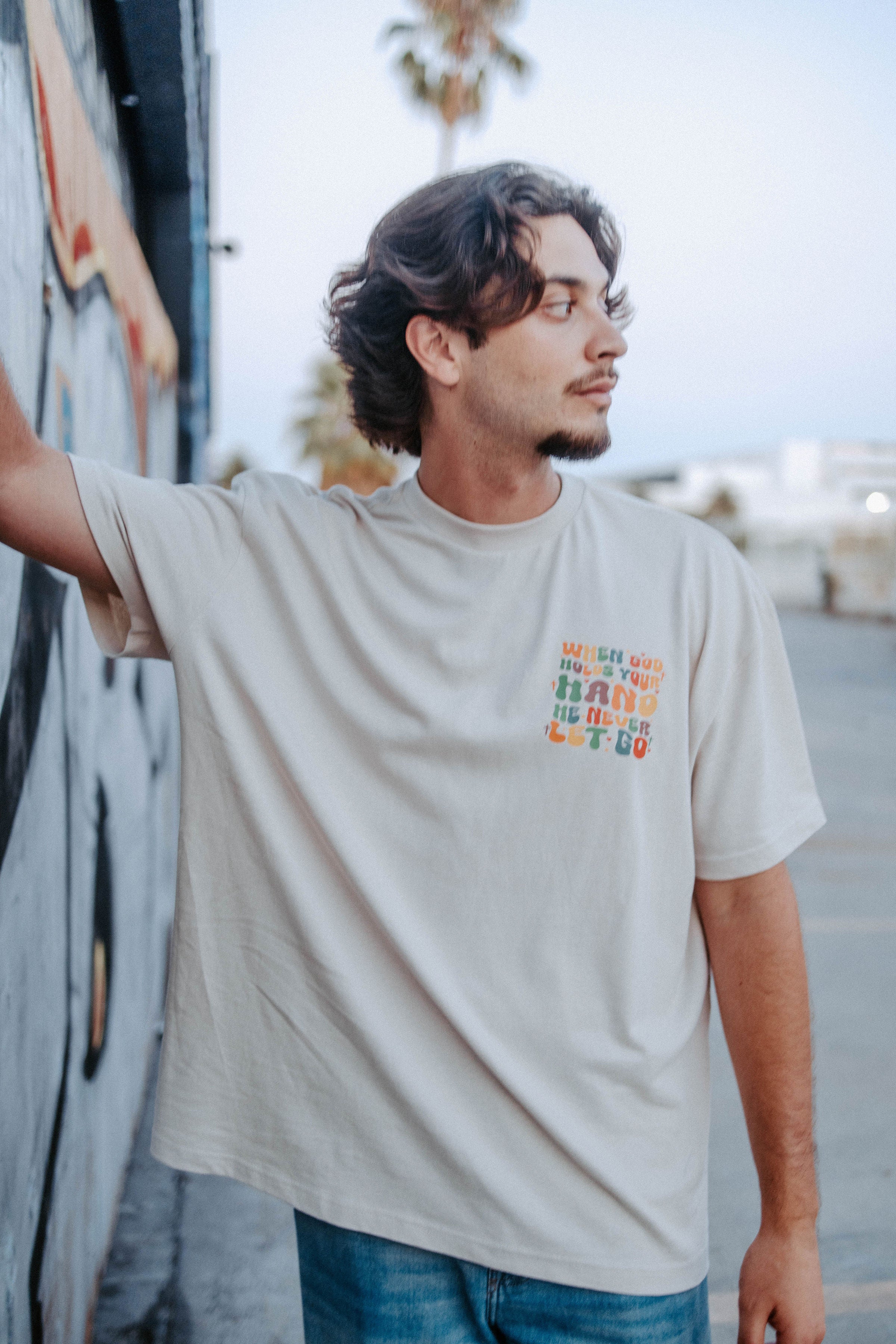 WHEN GOD HOLDS YOUR HAND TEE IN BEIGE