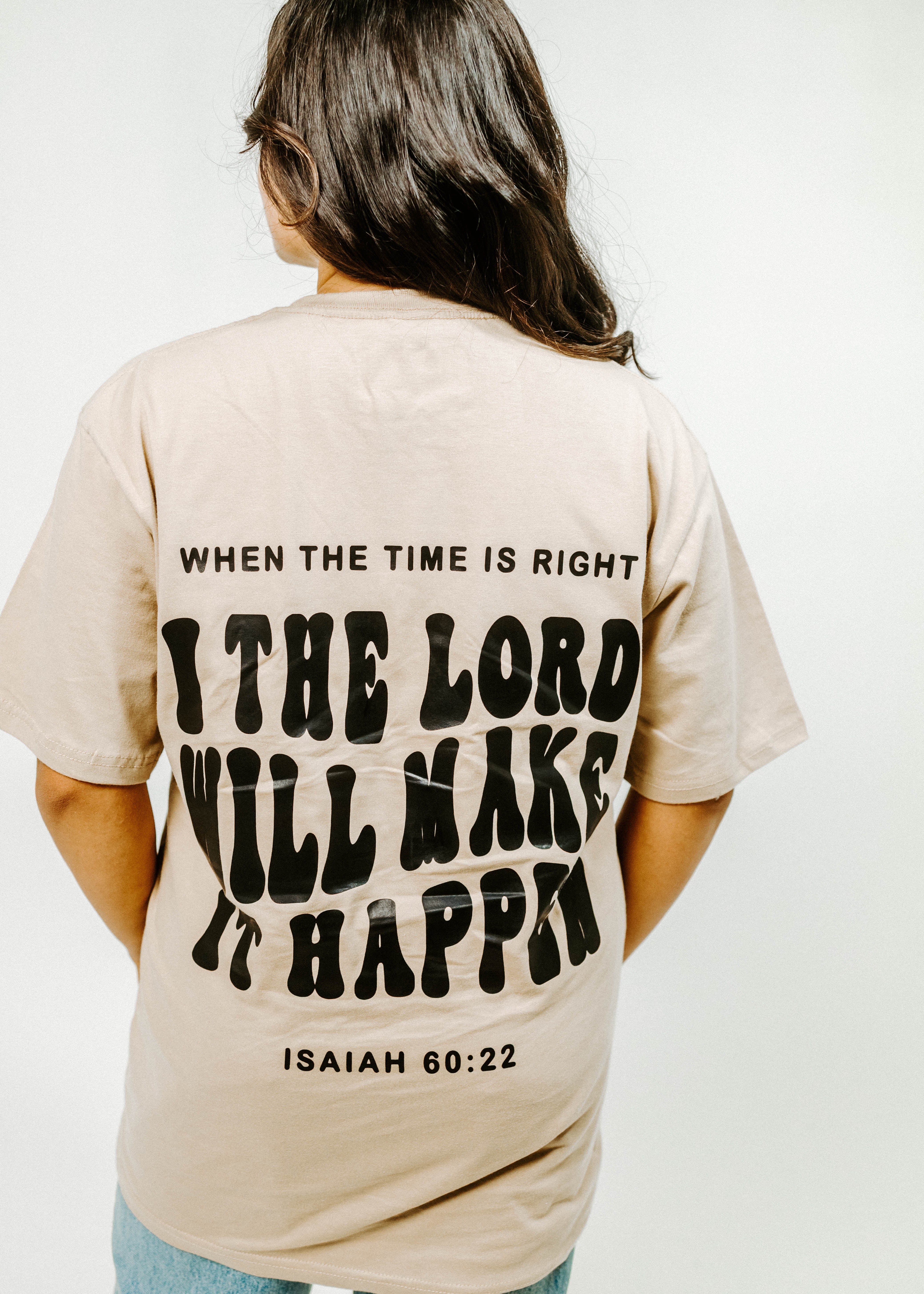 Person wearing a beige t-shirt with motivational quote on the back against a white background