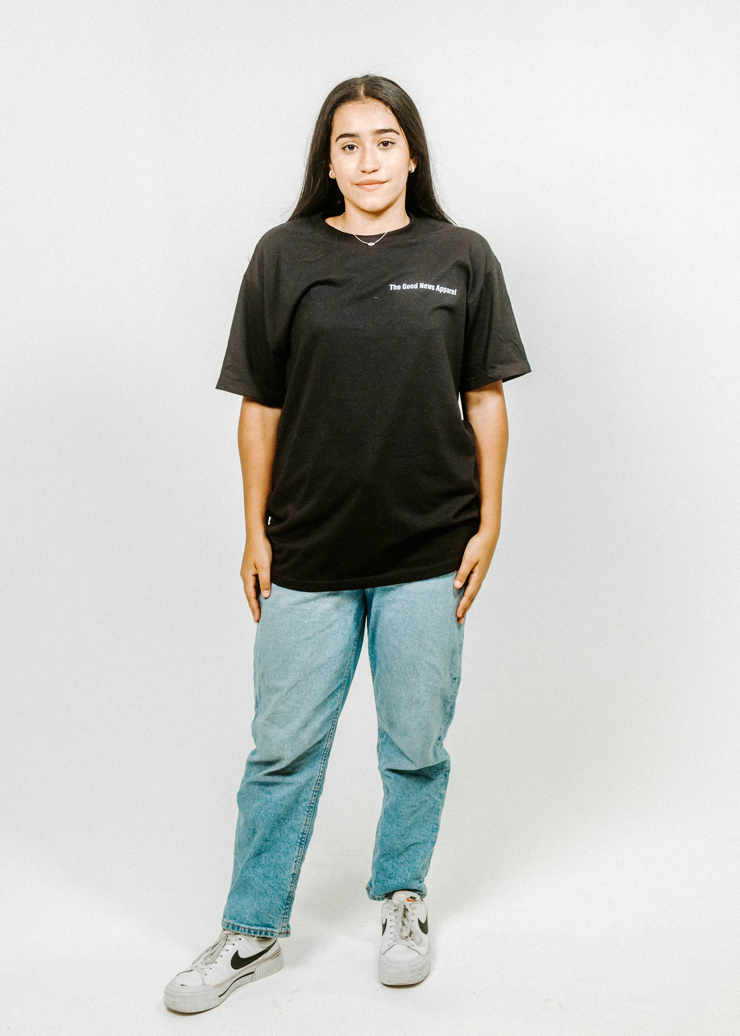 Person wearing a black t-shirt and light blue jeans on a white background