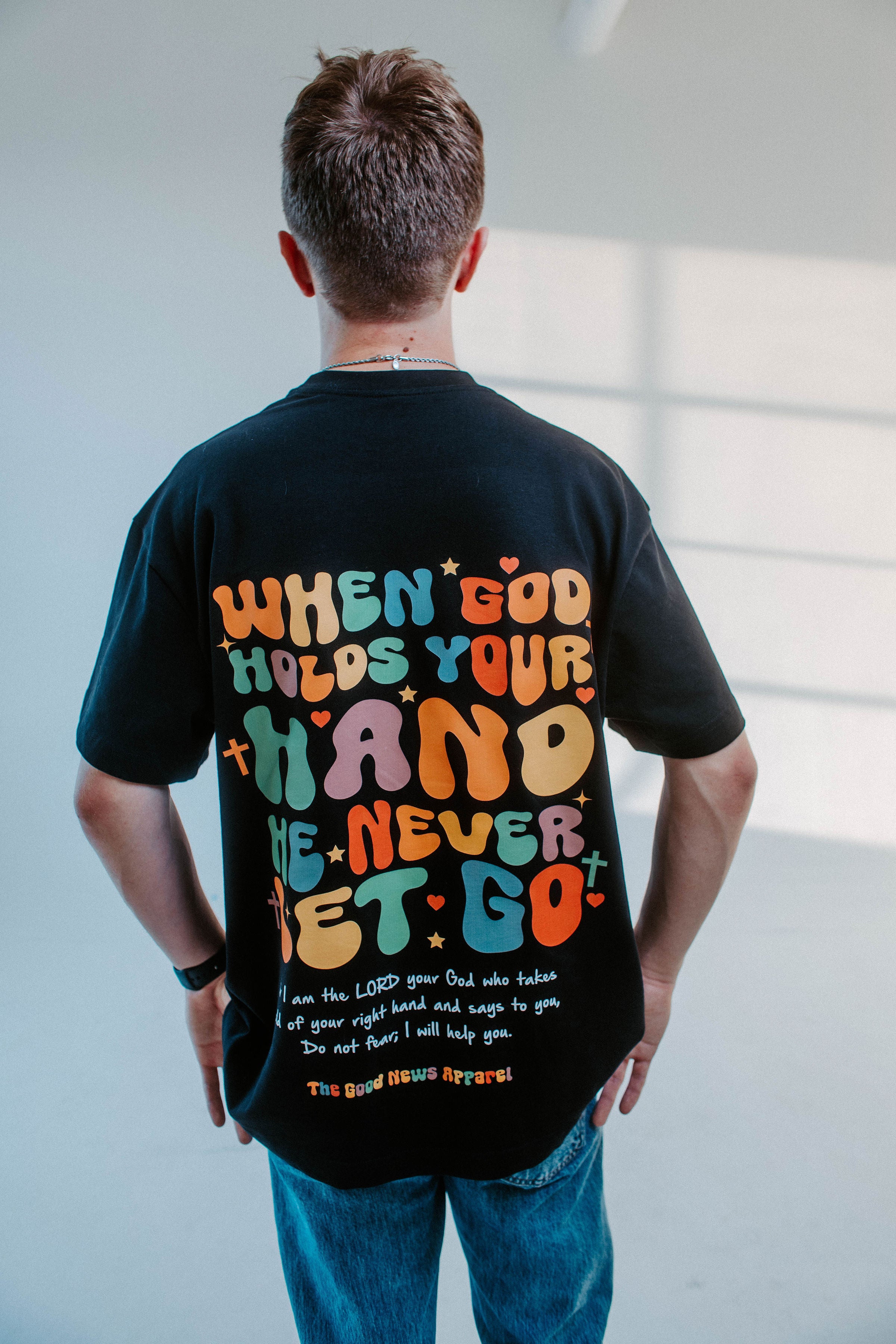 WHEN GOD HOLDS YOUR HAND TEE IN BLACK