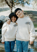Child wearing a Christian kids hoodie with the message “What a Friend We Have in Jesus” printed on the back.