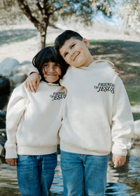 Child wearing a Christian kids hoodie with the message “What a Friend We Have in Jesus” printed on the back.