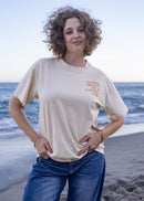 Woman wearing the Living Proof of a Loving God oversized Christian graphic tee in cream.