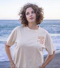Woman wearing the Living Proof of a Loving God oversized Christian graphic tee in cream.