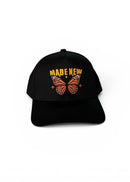 Black cap with butterfly design and 'MADE NEW' text on a white background
