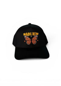 Black cap with butterfly design and 'MADE NEW' text on a white background