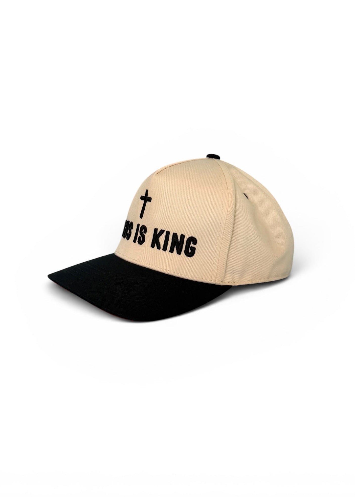 Beige and black cap with 'HE IS KING' text on a white background