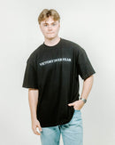 Person wearing a black t-shirt and light blue jeans on a white background