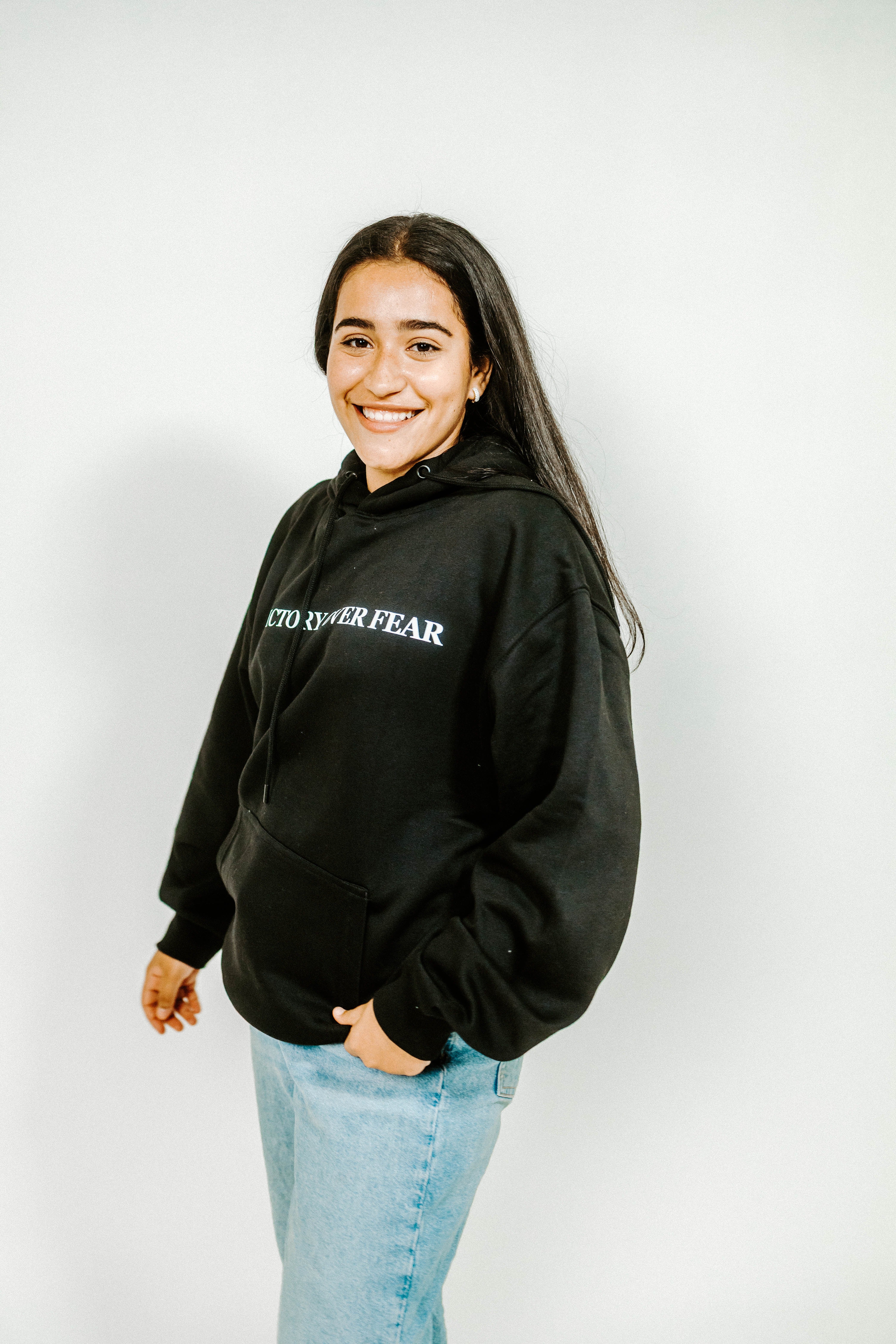 Person wearing a black hoodie with text on a white background