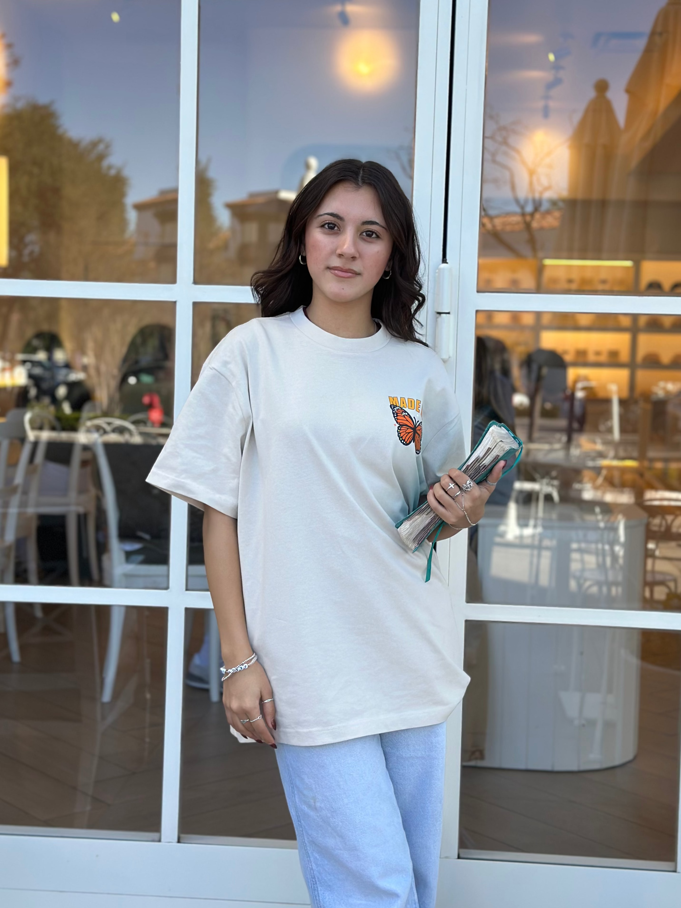 Woman standing in front of a glass door with a building reflection