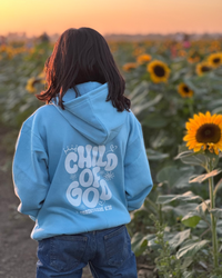 Child wearing a Christian kids hoodie with the message “Child of God” printed on the back.