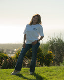 Person standing on a grassy field with a scenic background