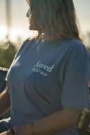 Person wearing a blue t-shirt with 'Saved by Grace' text, standing outdoors.