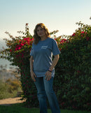 Woman standing outdoors with a scenic background