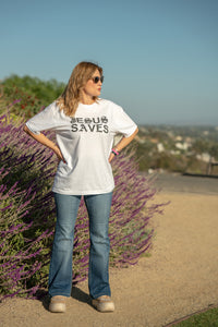 Woman wearing a 'JEHOVAH SAVES' shirt standing in front of lavender bushes.