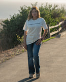 Woman standing on a path with greenery in the background