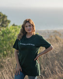 Woman wearing a green t-shirt with 'Victory Over Fear' text, standing outdoors.