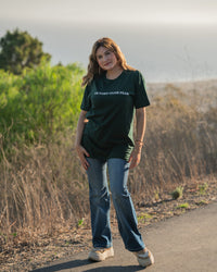 Woman standing on a path with greenery in the background