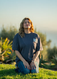 Woman sitting on grass with a scenic background