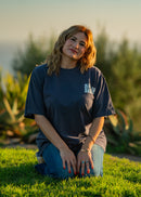 Woman sitting on grass with a scenic background